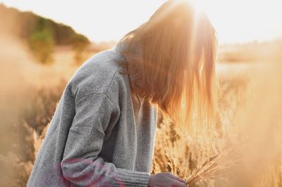 Midsection of woman on field against sky