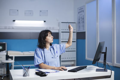 Young woman using mobile phone in office