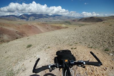 Bicycle parked on desert against sky