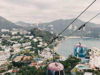 High angle view of overhead cable car by buildings against sky