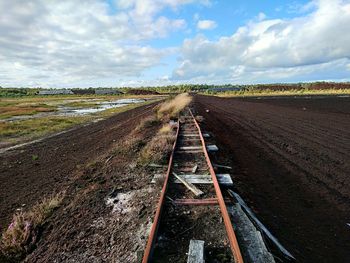 Railroad tracks on land against sky