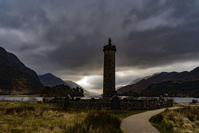 Tower of building against cloudy sky