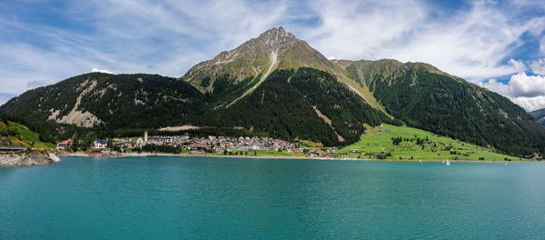 Scenic view of sea by mountains against sky