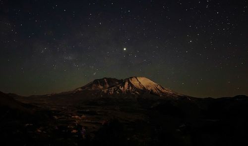 Scenic view of snowcapped mountains against sky at night