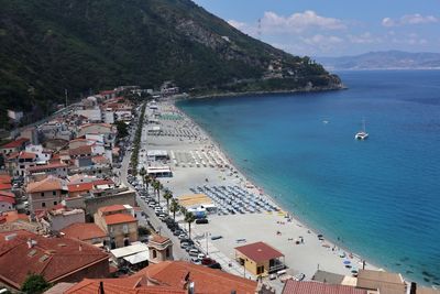 High angle view of boats on sea shore by buildings