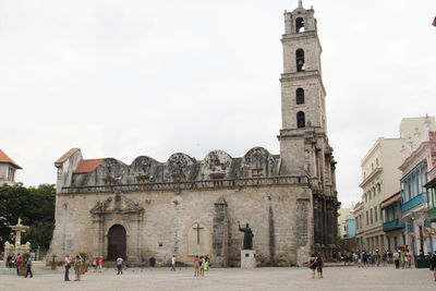 Group of people in historic building against sky in city