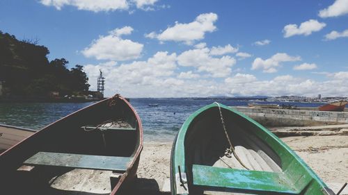 Close-up of boats moored in sea against sky