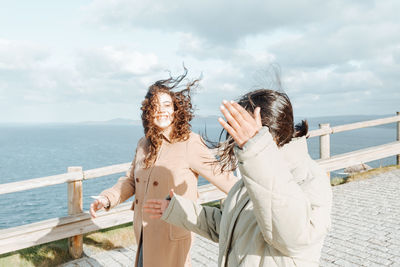 Rear view of woman standing against sea