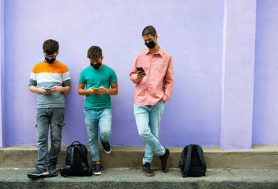 Full length of man standing on mobile phone