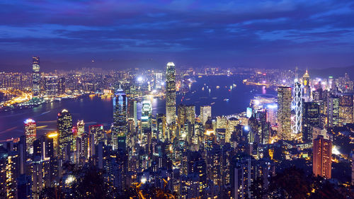 Illuminated cityscape against sky at night