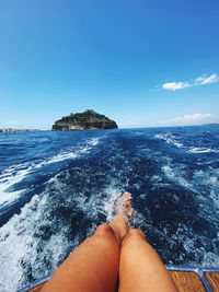 Low section of woman in sea against sky