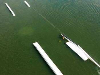 Wakeboarding surfing and doing trick in wake park from above.