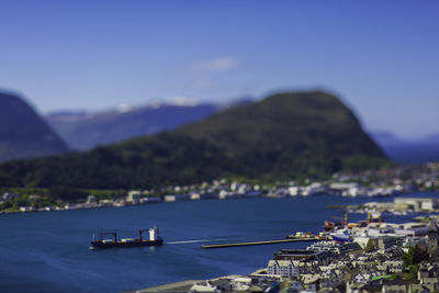 Scenic view of sea and mountains against blue sky