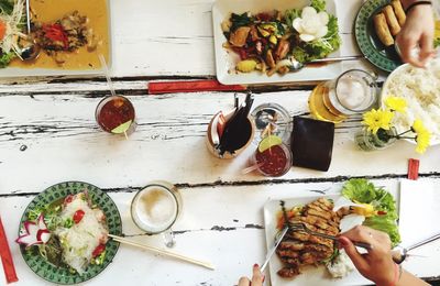 Cropped image of people having food served on table