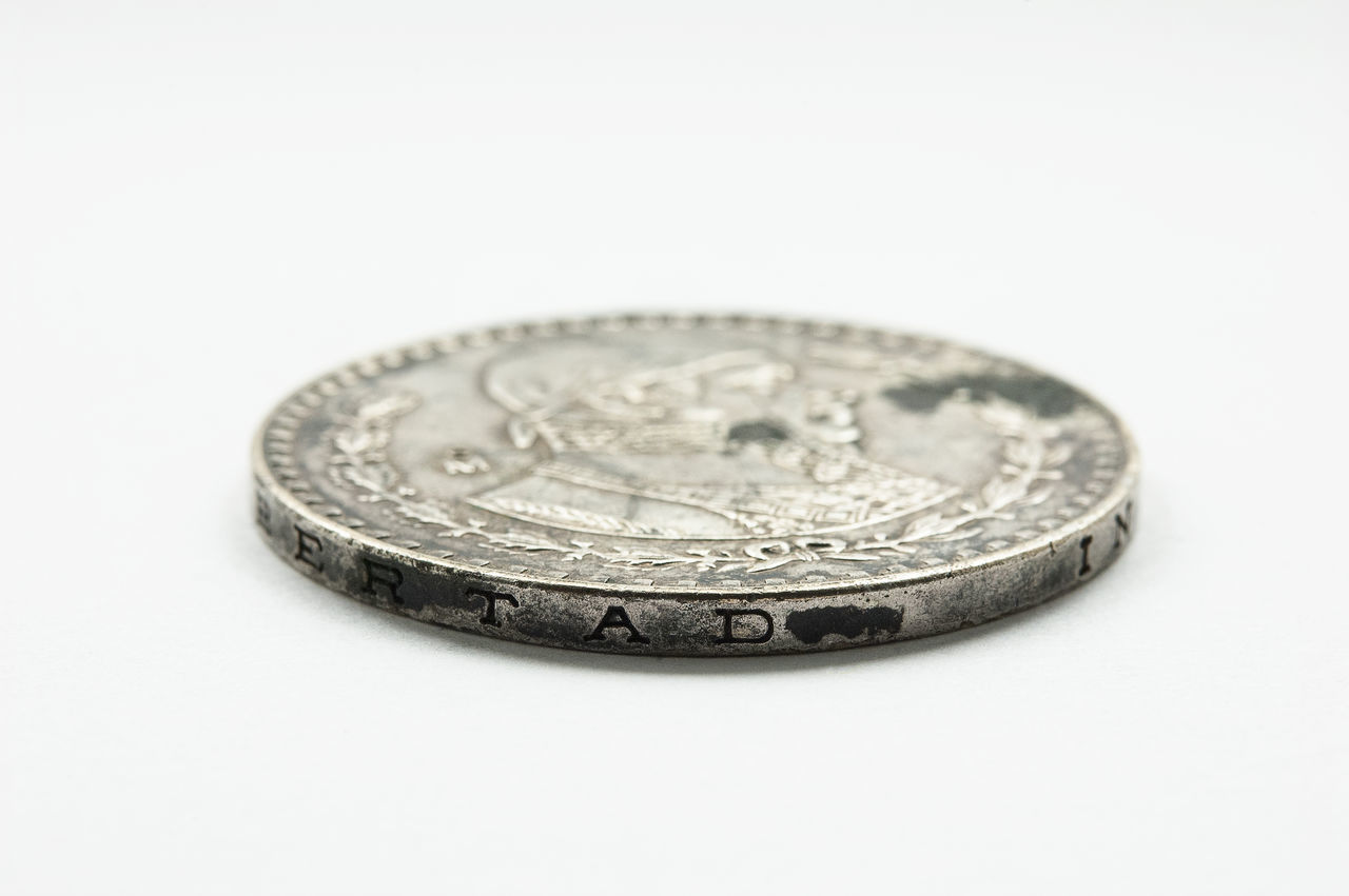 CLOSE-UP OF COINS IN WHITE BACKGROUND