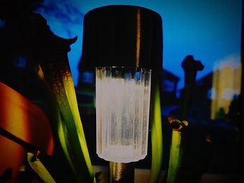 Close-up of illuminated lights on glass at night