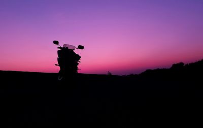 Silhouette man standing on field against sky during sunset