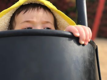 Close-up of child looking away in play equipment