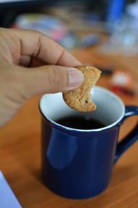 Close-up of hand holding coffee cup