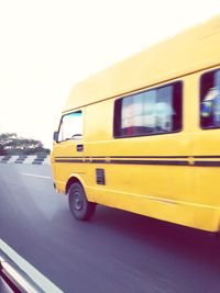 Close-up of yellow car on road