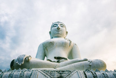 Low angle view of buddha statue against sky