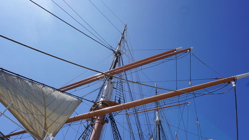 Low angle view of sailboat against clear blue sky