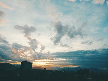 Aerial view of buildings in city against sky at sunset