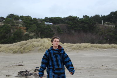 Portrait of young man standing on beach