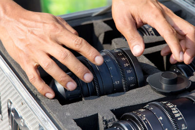 Cropped image of man keeping camera in suitcase