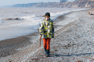 Front view of boy walking on beach