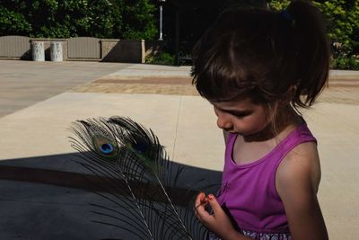 Close-up of girl looking at bird