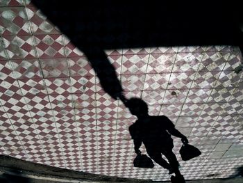 Shadow of man on tiled floor