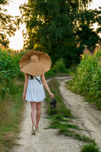 Young beautiful woman with summer hat in the corn field.