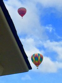 Low angle view of hot air balloons flying against sky