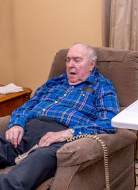 Senior man sits in his lift chair and sleeps through the day