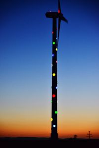 Low angle view of illuminated lights against clear sky at sunset