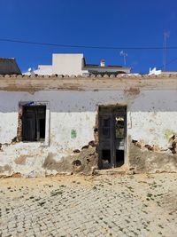 Abandoned building against clear blue sky