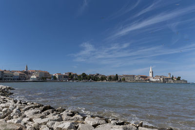 Porec waterfront with blue sky and rocks