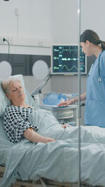 Nurse checking on senior patient in clinic