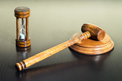 High angle view of gavel with hourglass on wooden table