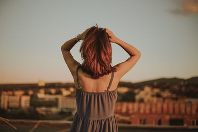 Rear view of woman standing against clear sky