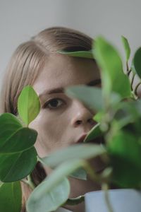 Close-up of young woman against plants