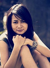 Portrait of smiling woman sitting outdoors