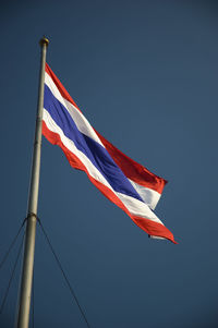 Low angle view of flags flag against clear blue sky