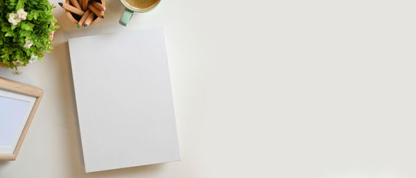 High angle view of open book on table against white background