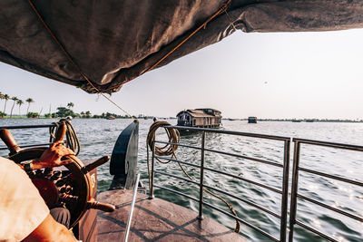 Midsection of man sailing boat in sea against clear sky