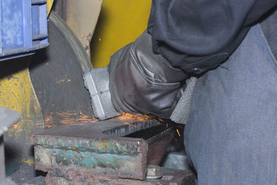 Midsection of man working at workshop