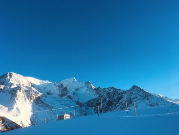 Scenic view of snowcapped mountains against clear blue sky