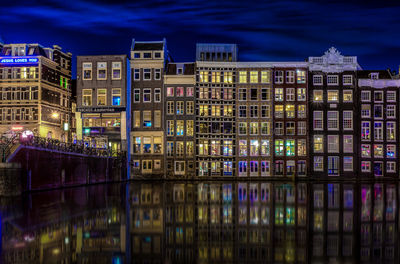 Illuminated buildings reflection in canal at night