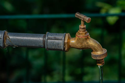 Close-up of water faucet against blurred background